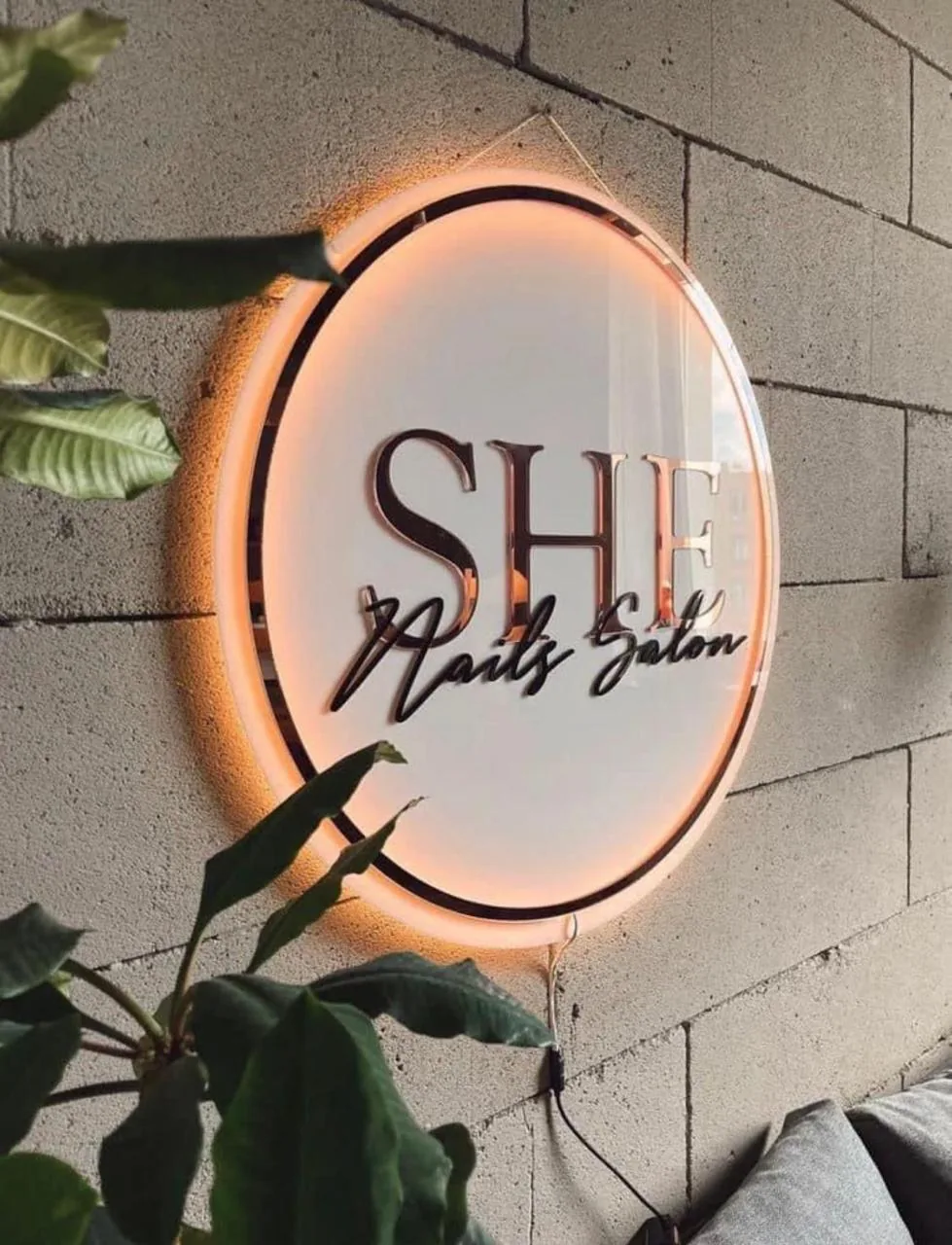 Letrero circular con luz cálida de SHE Nails Salon