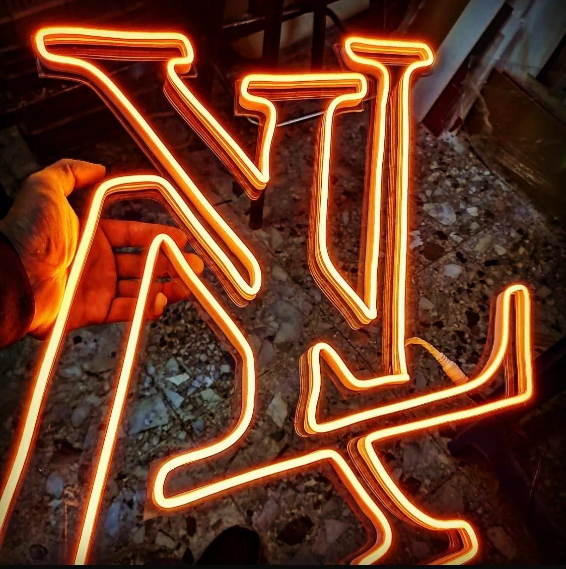 Letras de neón en naranja recién fabricadas en el taller