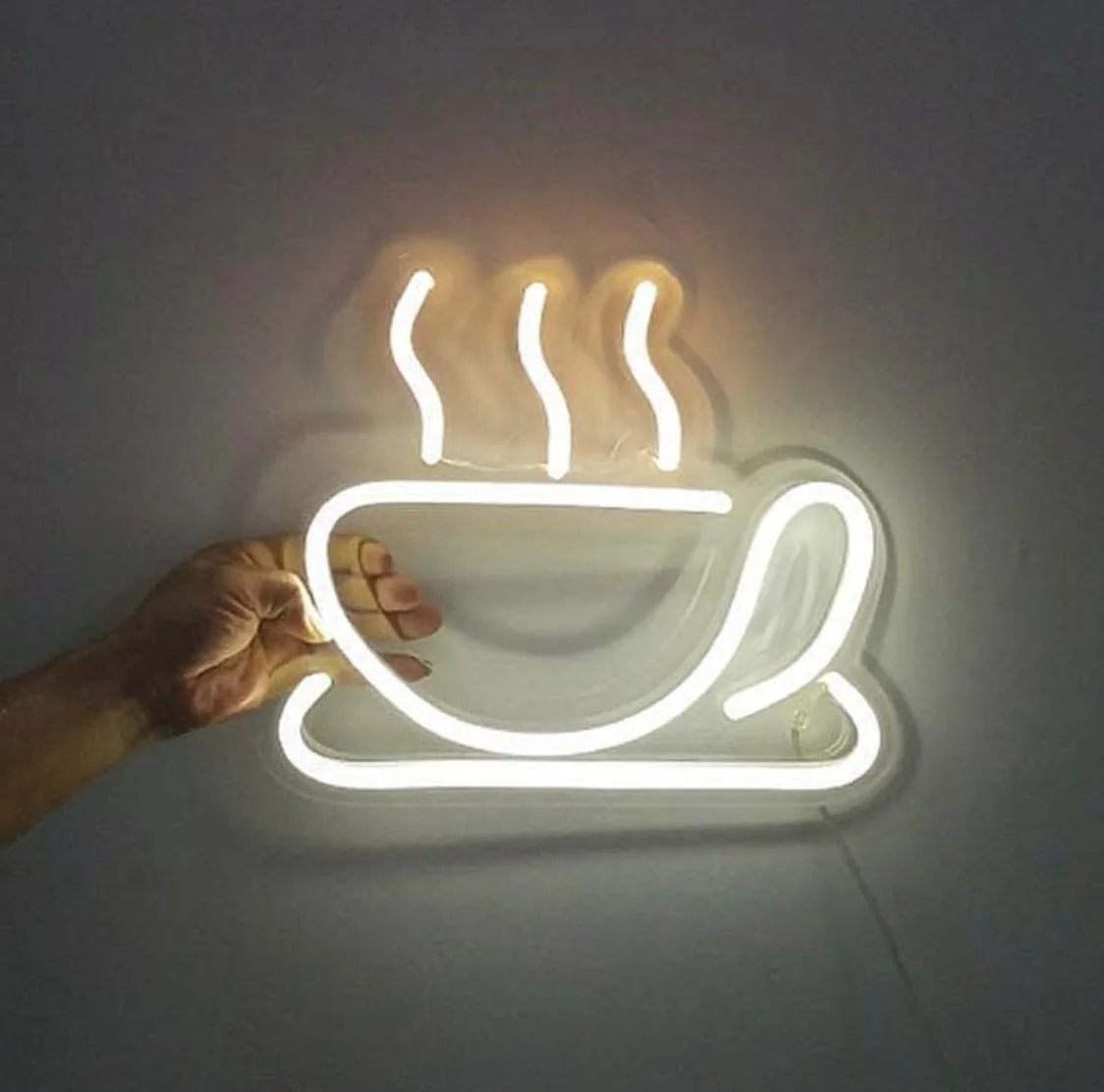 Figura de neón de una taza de café humeante