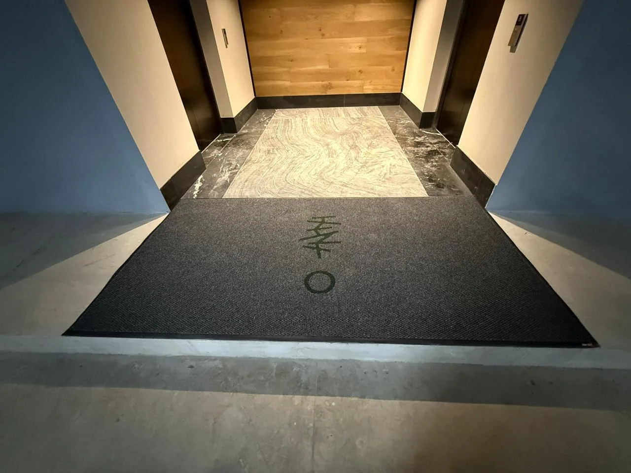 Tapete de alfombra instalado frente a los elevadores